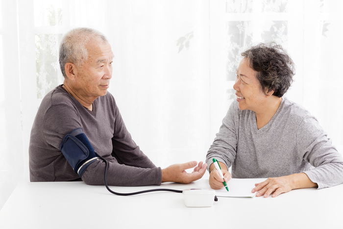 happy Senior couple taking  blood pressure in living room